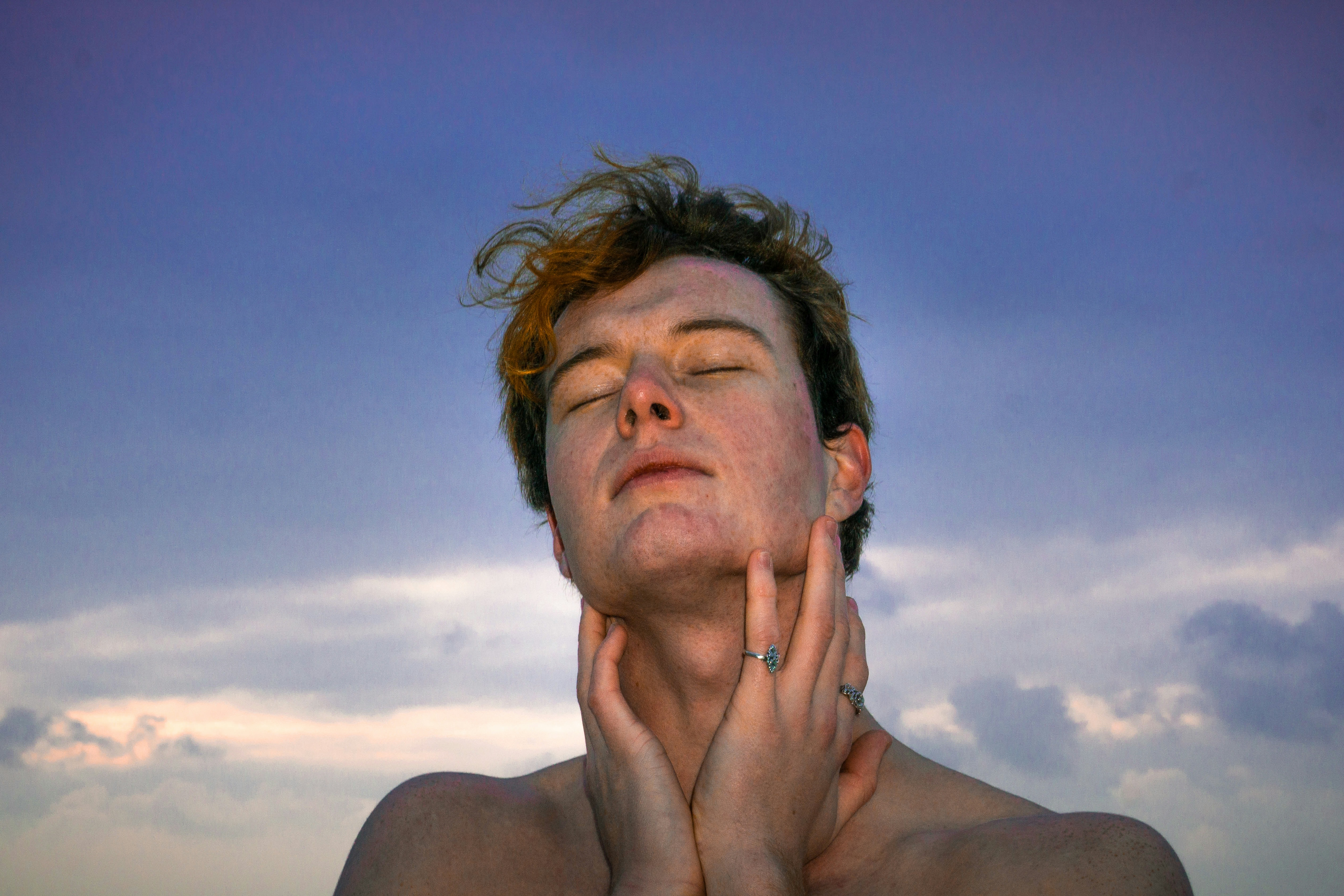 Portrait of a young white man in front of a blue sky. © Tal Ben Yakir