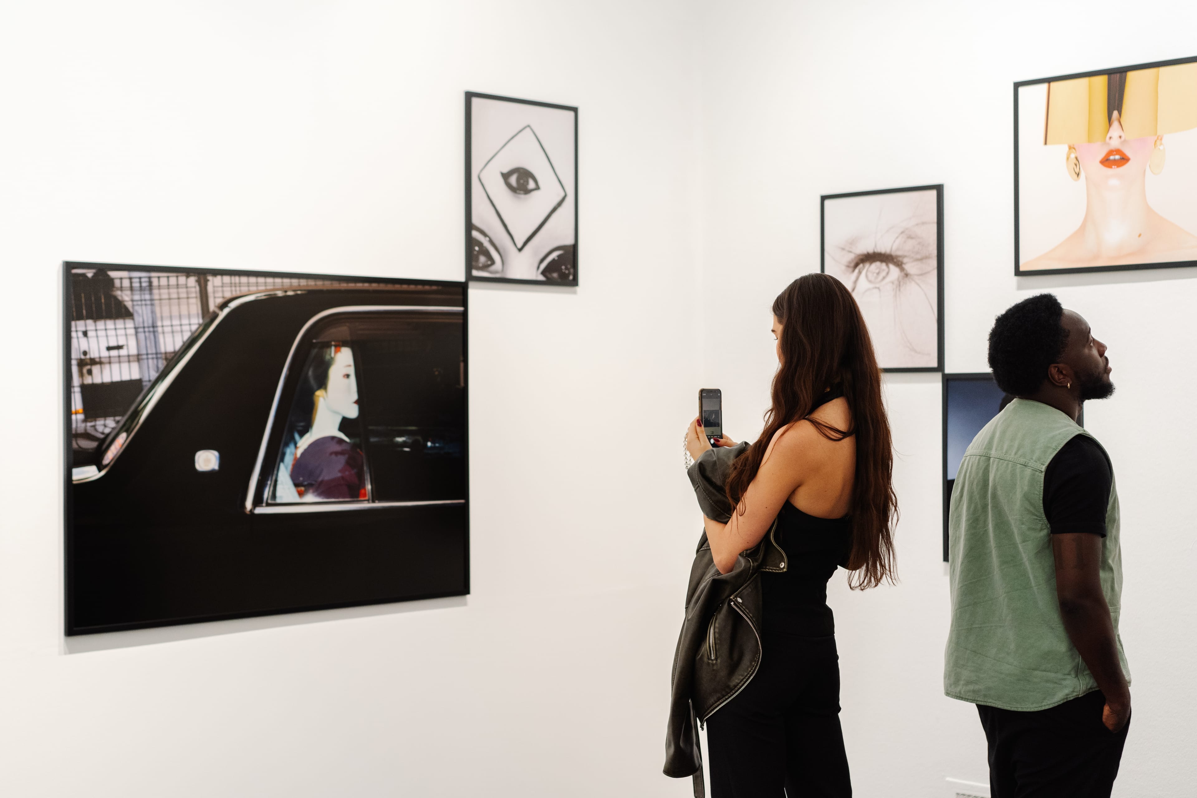 Two people viewing artworks.