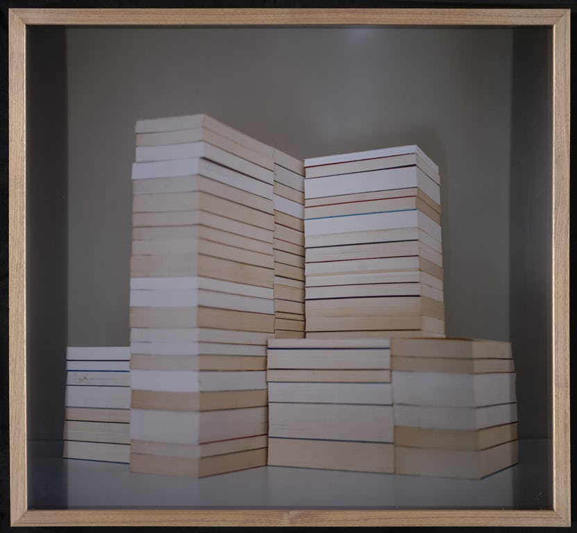 Several piles of unidentified white and beige books, shaped like large skyscrapers. Photograph by Katja Mater.