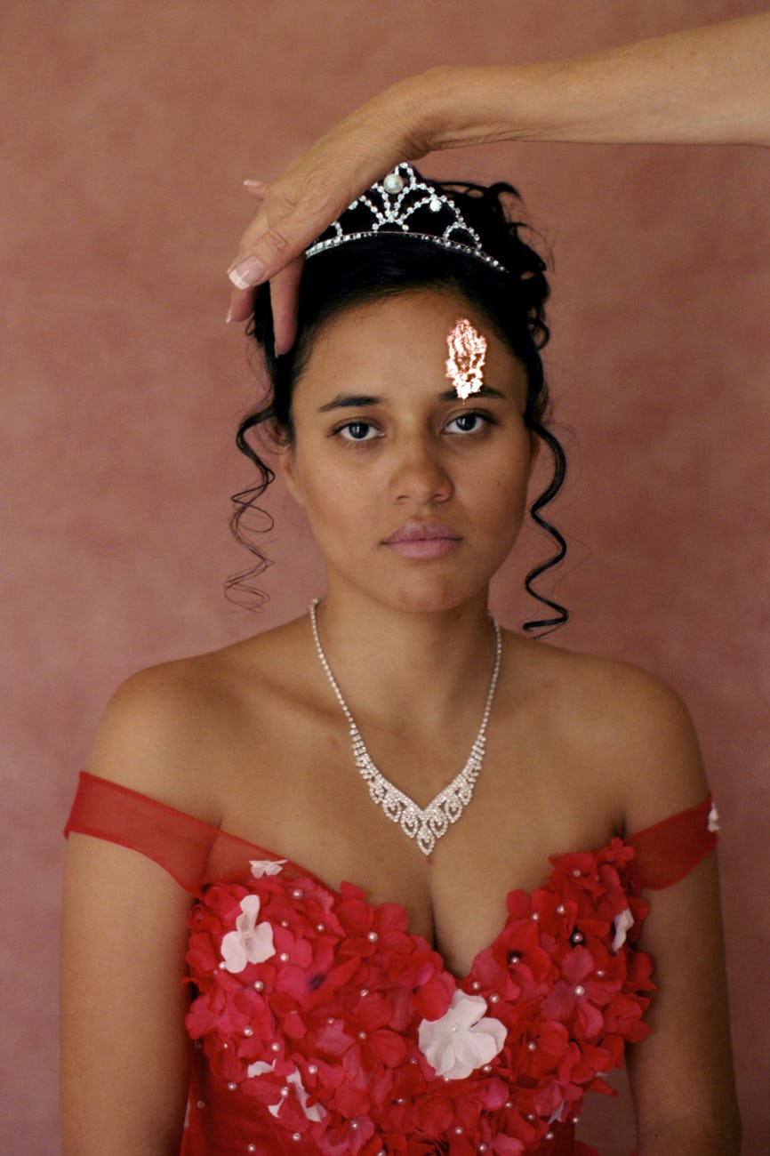 Portrait of a young woman wearing a red dress and silver crown © Marisol Mendez