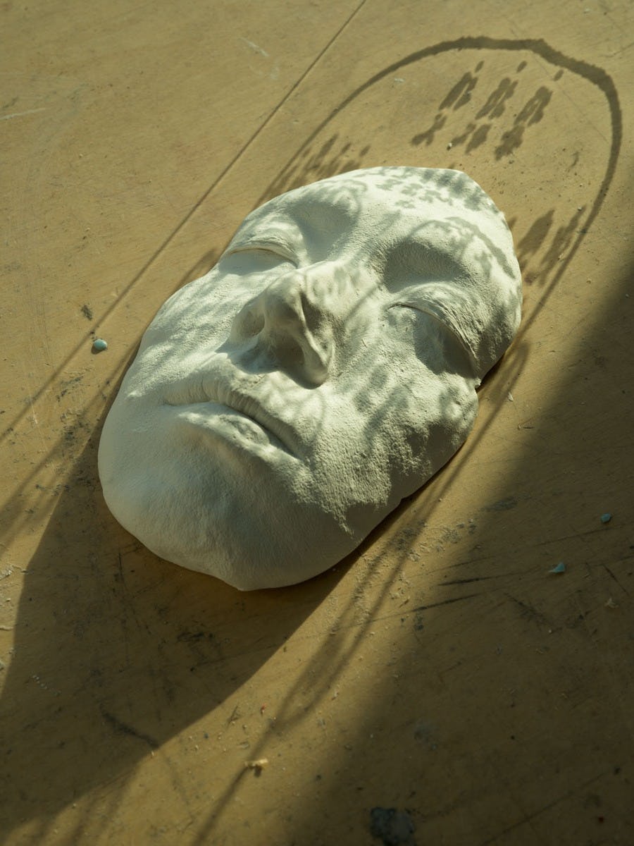 Photograph of a white face cast, with a Chinese face reading projected on top© Sheung Yiu